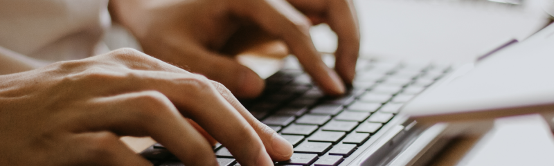 Hands typing close up on a computer keyboard 