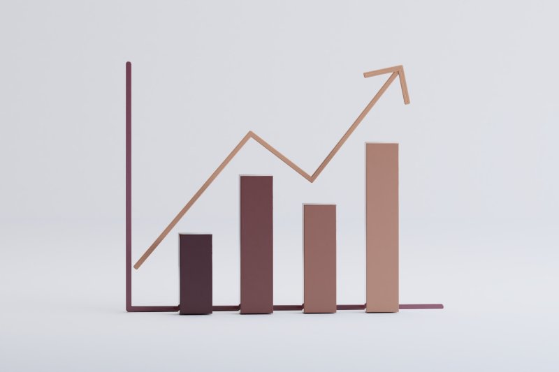 3D bar graph with increasing vertical bars and an overlaid upward-trending line graph, symbolising growth and performance improvement.
