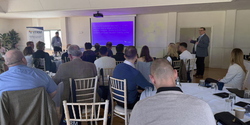 Attendees at ITRM's Intelligent AI Solutions Showcase in Bristol watching a presentation on practical AI applications for businesses.