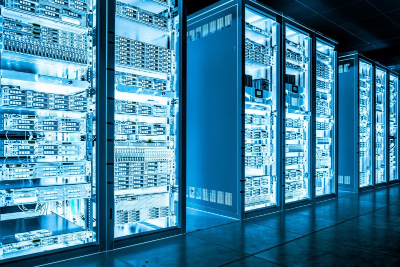 Organised data center with illuminated server racks and blue lighting, representing secure and high-performance networking infrastructure.