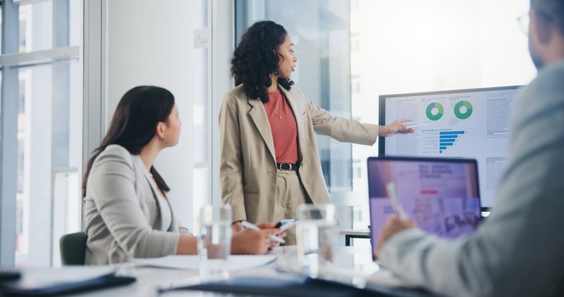 Finance professional pointing at a screen