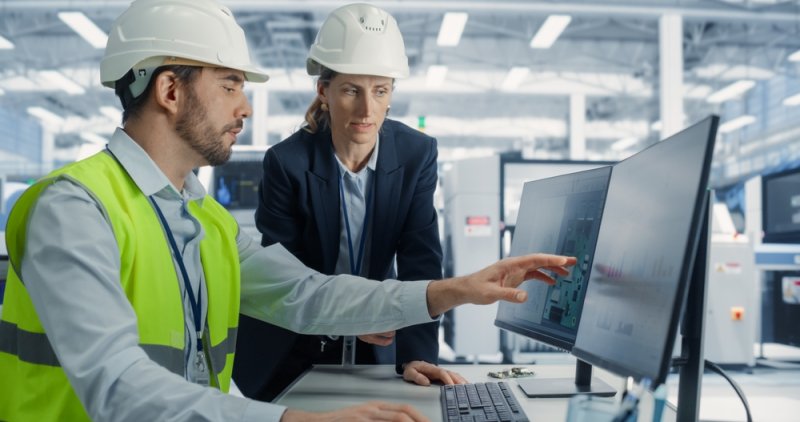Man and women in hardhat working on a PC