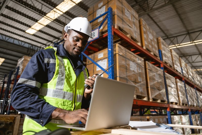 Man in warehouse working on a laptop