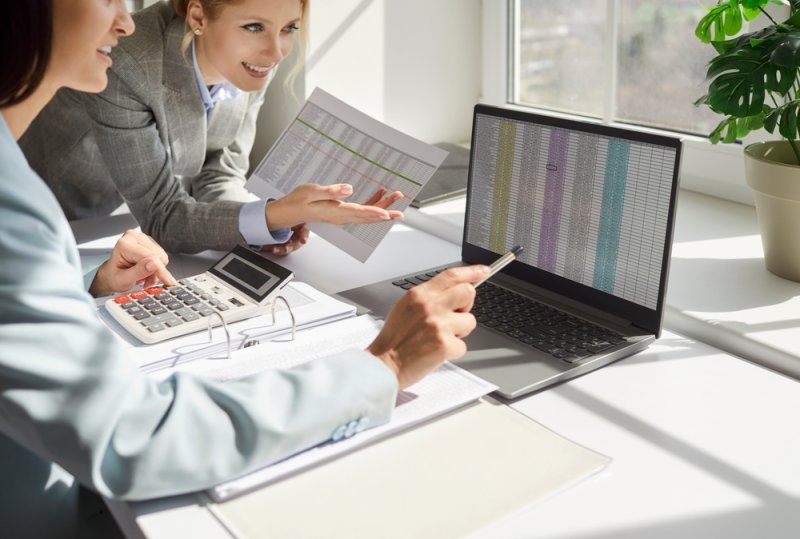 Business workers analysing stock on spreadsheet